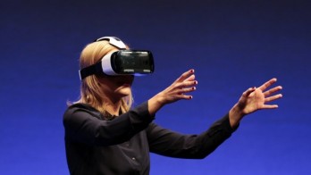 FILE - In this Wed., Sept. 3, 2014 file photo, British television presenter Rachel Riley shows a virtual-reality headset called Gear VR during an unpacked event of Samsung ahead of the consumer electronic fair IFA in Berlin. Oculus, the virtual reality company acquired by Facebook earlier this year for $2 billion, is holding its first-ever developers conference and is expected to discuss the much-anticipated release of its VR headset for consumers. The two-day Oculus Connect conference begins Friday, Sept. 19, 2014. (AP Photo/Markus Schreiber, file)